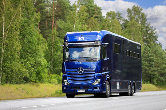 Blue Mercedes-Benz Actros 2648 Krismar horse truck, horse transporter at speed on highway on a day of summer. 