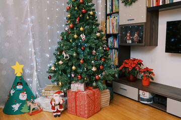 Colorful gifts under decorated Christmas tree in room