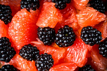 Fruit salad with grapefruit and blackberries in gray ceramic bowl. Selective focus. Shallow depth of field.