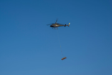 Air transport of materials using a helicopter for a construction site