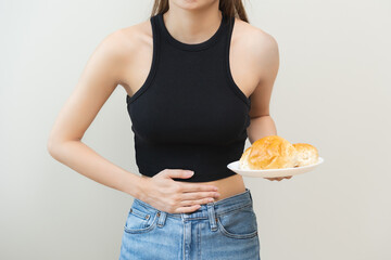 Gluten allergy, asian young woman hand holding, refusing to eat white loaf slice on plate in...