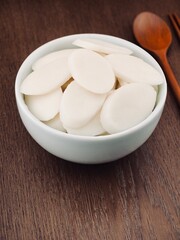 도자기 그릇에 담긴 떡국떡과 숟가락, 젓가락