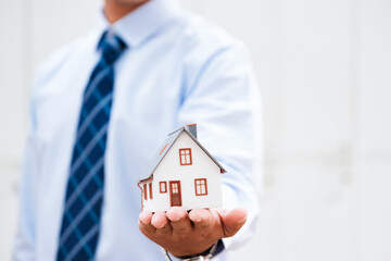 Real Estate Agent Protecting House Model in Hand