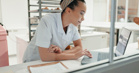 Research, smile and laptop with chef in kitchen for online recipe, restaurant review or food industry. Cafe, menu planning and cooking website with person in coffee shop for nutritionist and internet