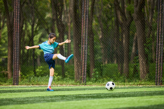 Fototapeta Chinese Girl Playing Football on Soccer Field