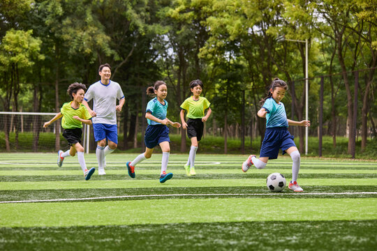Chinese Kids Playing Football on Soccer Field