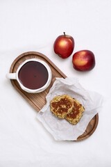 Enjoying a Cozy Breakfast with Tea, Fresh Apples, and a Snack of apple pancakes on a Beautiful Wooden Tray