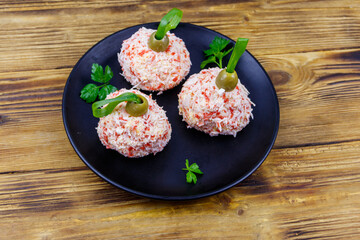 Appetizer of crab-cheese balls made in a shape of Christmas baubles on wooden table