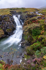 Waterfall in Autumn with flowering heather plants growing around
