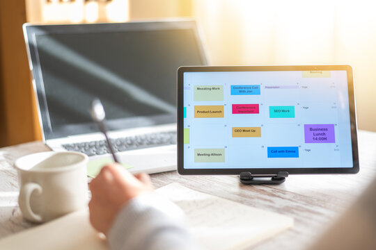 Business Person Planning Calendar Appointments And Scheduling Client Meetings Using Digital Tablet In Office. Successful Entrepreneur Organizing Their Professional Agenda.
