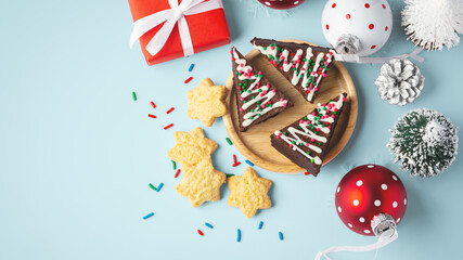 Christmas chocolate brownies and cookies with christmas decor on blue background