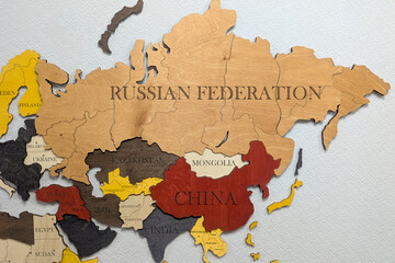 Eurasia Continent on political map. Wooden world map on wall.