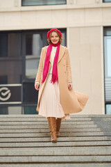 A woman strolls confidently down the stairs in a stylish outfit during a sunny afternoon