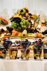 glass filled with fresh berries. The glass contains raspberries and blackberries, garnished with fresh mint leaves and sprinkled with powdered sugar.