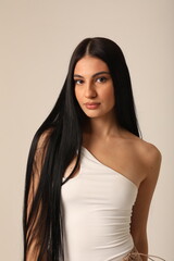 Fototapeta premium Headshot of beautiful young woman with long dark hair looking at the camera. Vertical mock-up.