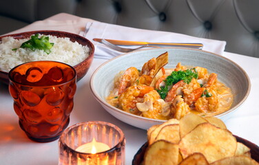 shrimp stroganoff with potato chips and white rice on the table
