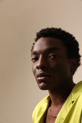 Obraz premium Portrait of young African American man looking at the camera and posing over light background. Vertical mock-up.