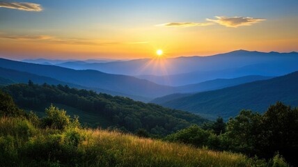 Obraz premium A stunning sunset casts warm hues over rolling hills and valleys, creating a serene landscape that captures the beauty of nature.