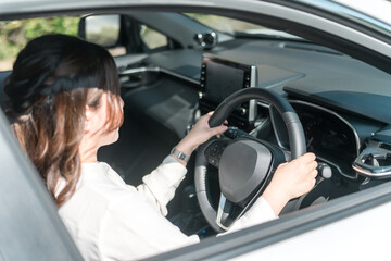 車のハンドルを持つ女性ドライバーの手元

