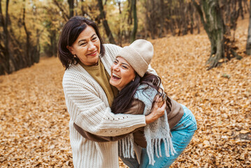 Fototapeta premium Mature daughter with older mom in the middle of fores, hugging. Mother's day concept.