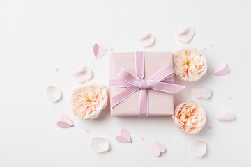 Beautiful greeting card for Valentine or Mothers Day. Pink hearts, rose flowers and gift box top view. Flat lay.