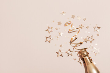 Party background with champagne and golden confetti stars. Christmas, birthday or wedding concept. Flat lay. © juliasudnitskaya