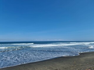 A peaceful escape awaits on this secluded beach. The calm waters and clear blue sky create a serene atmosphere, perfect for relaxation