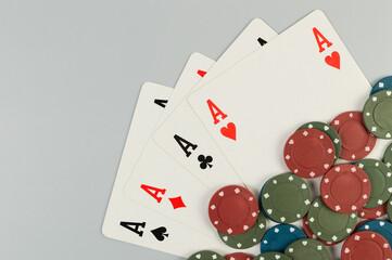 Top view of playing cards, poker chips on grey background. Four aces cards, board game, poker. Copy space, flat lay.