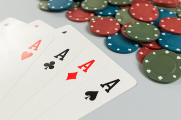 Top view of playing cards, poker chips on grey background. Four aces cards, board game, poker. Copy space, flat lay.