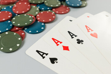 Top view of playing cards, poker chips on grey background. Four aces cards, board game, poker. Copy space, flat lay.