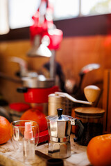 Moka pot on the table at home. Coffee making concept.  Moka pot, bean spray, coffee grinder, jar of coffee beans standing on the kitchen table.