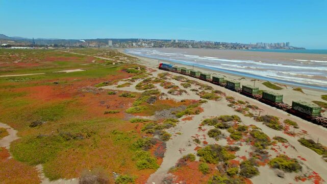 Train rides coastline of Ritoque, Valparaiso Chile Cargo Transport Aerial View Shipping Containers