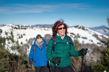 Active seniors enjoying winter nature. Romantic winter hike for an elderly couple in snowy...