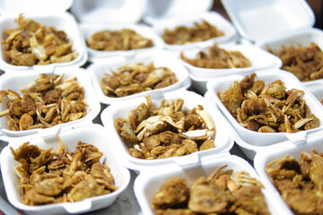 Many small white containers hold fried crab pieces.