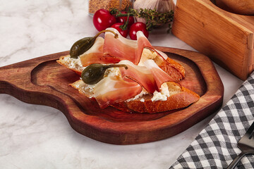 Bruschetta with jamon and caper berries