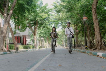 Naklejka premium Commuting to work with bicycle. Young business person cycling and riding electric scooter to office in downtown district. Modern diversity people use eco transportation in city. Sustainable lifestyle.