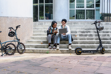 Commuting to work with bicycle. Young business person cycling and riding electric scooter to office in downtown district. Modern diversity people use eco transportation in city. Sustainable lifestyle.