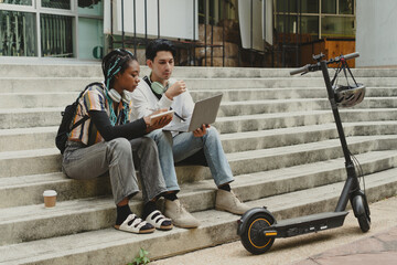 Commuting to work with bicycle. Young business person cycling and riding electric scooter to office in downtown district. Modern diversity people use eco transportation in city. Sustainable lifestyle.