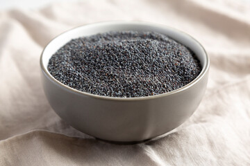 Raw Organic Dry Poppyseeds in a Bowl, side view.
