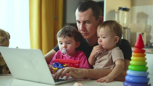 Father's Day joy as dad and kids bond at desk, computer games and laughter blend. Desk becomes hub of family fun, computer games led by dad. Computer at desk dad teaches plays celebrates with kids.