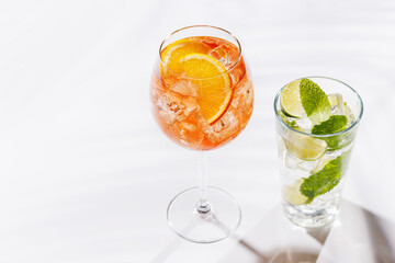 A vibrant Aperol spritz and Mojito cocktails