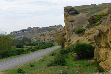 An asphalt road next to the cliff leads to the ruins of the city. Uplistsikhe is an ancient rock-hewn town.