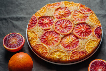 Delisious freshly baked homemade blood orange upside-down cake on grey background, close-up....