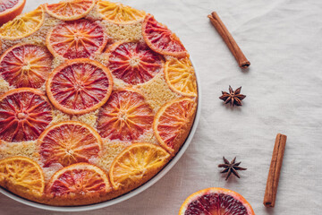 Delisious freshly baked homemade blood orange upside-down cake on neutral background, close up. Popular winter holiday dessert.