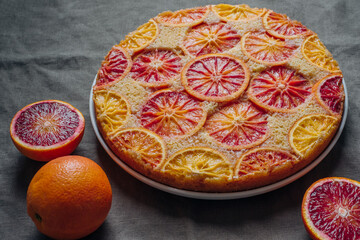 Delisious freshly baked homemade blood orange upside-down cake on grey background. Popular winter...
