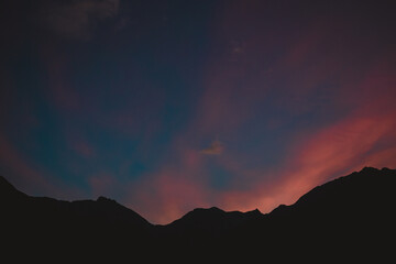 Mountains silhouetted against a orange and blue sunset