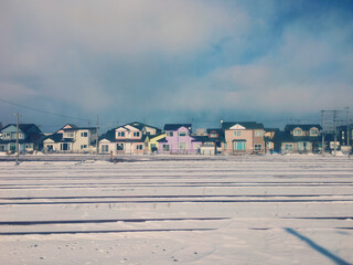 colorful little house in winter, and railway covered with snow