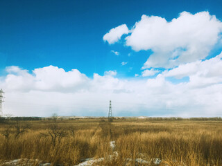 clouds over the field in autumn / winter under the blue sky