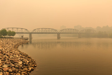 A bridge over a river with a foggy sky in the background