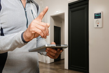 Closeup photo of man with tablet accounting electric bill charges, Tablet displaying electricity...